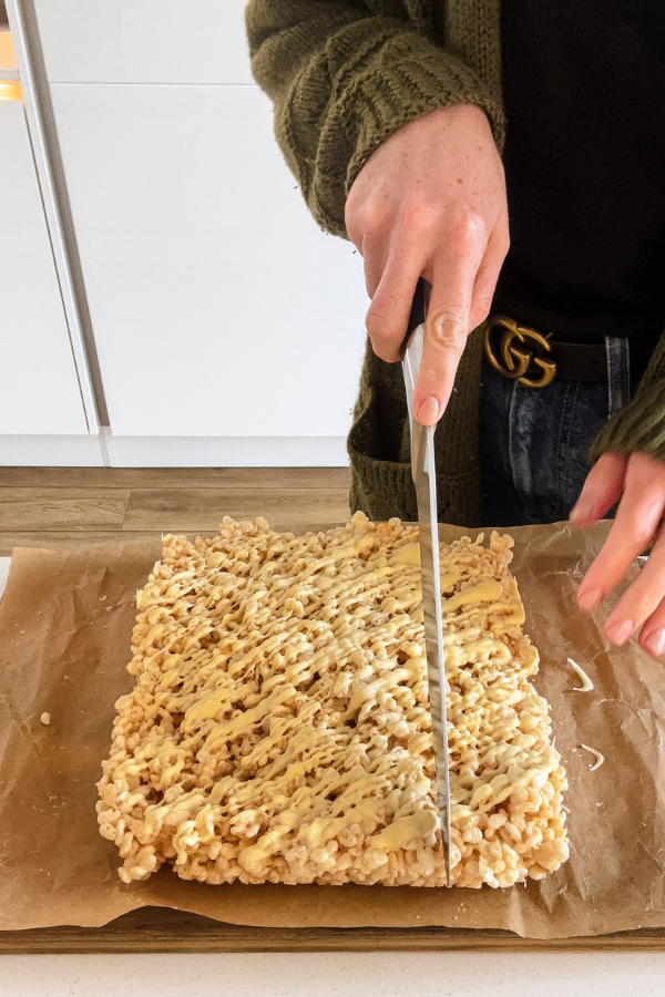 cutting into my rice krispie quares recipe covered with melted white chocolate